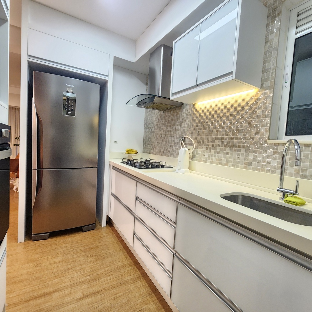 Cozinha em corredor com geladeira inox e bancada branca — Edifício Belvedere