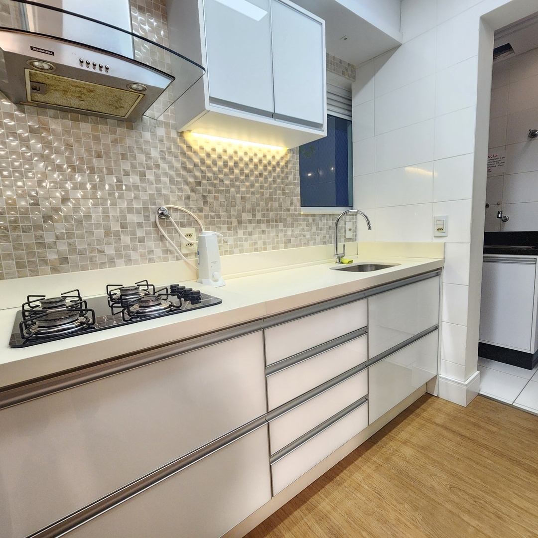 Cozinha gourmet com coifa inox e bancada branca — Edifício Belvedere